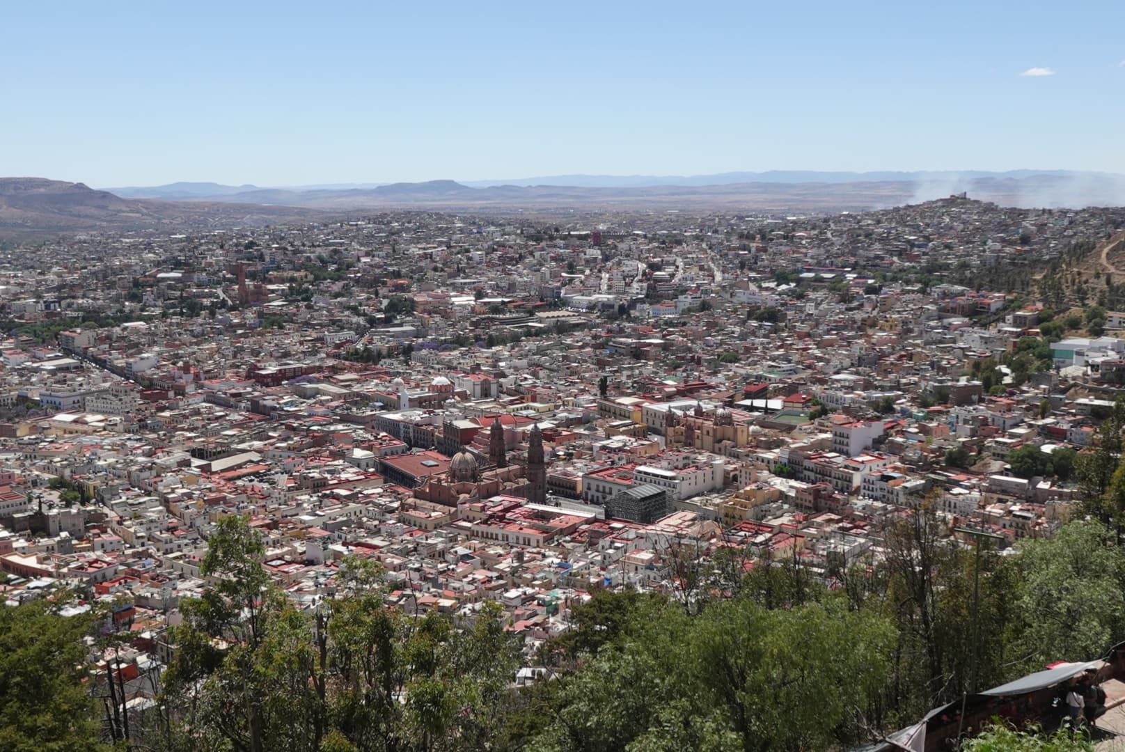 Zacatecas city rooftops and church towers surrounded by dry hills, viewed from Cerro de la Bufa