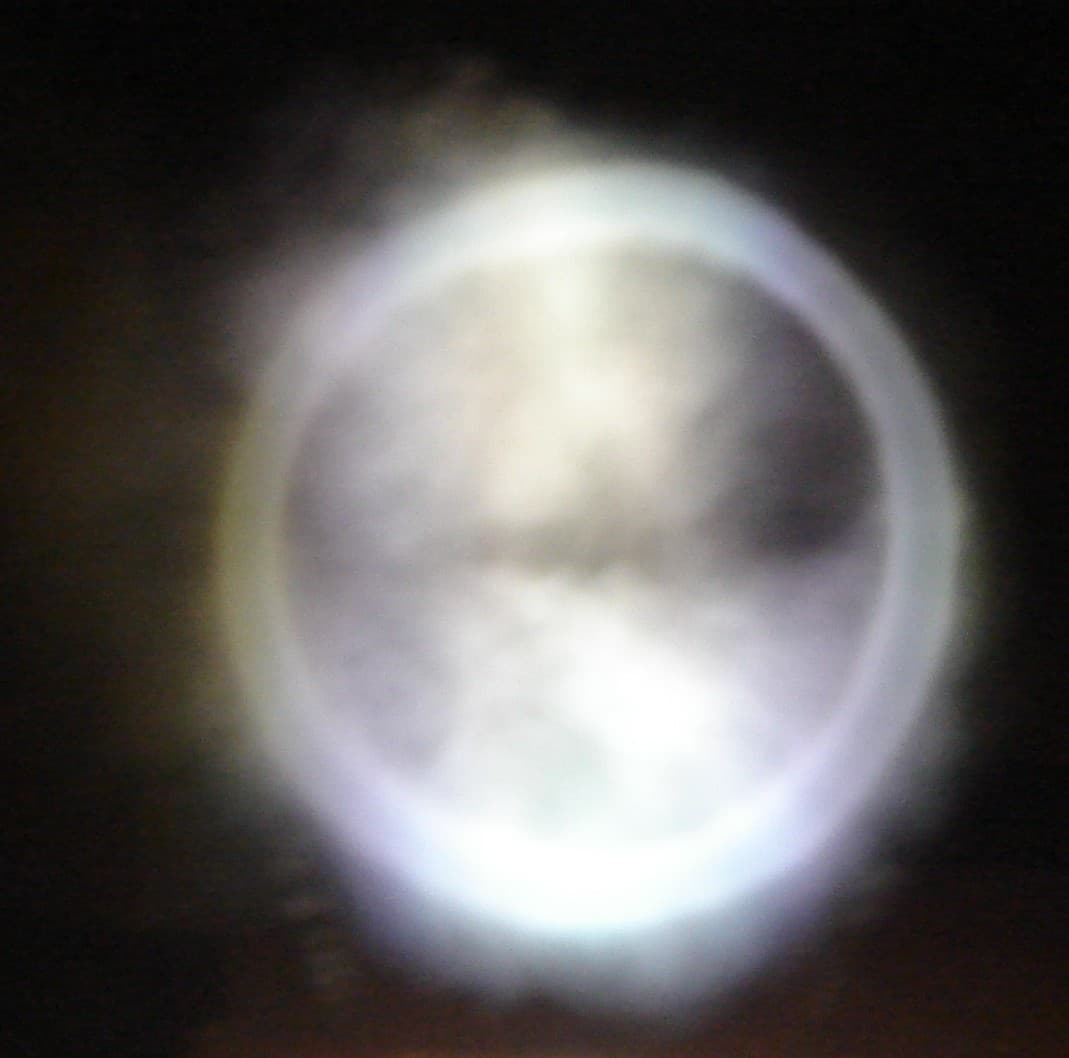 Pale smoke ring with a hollow center against a dark background in a Bonn University demonstration