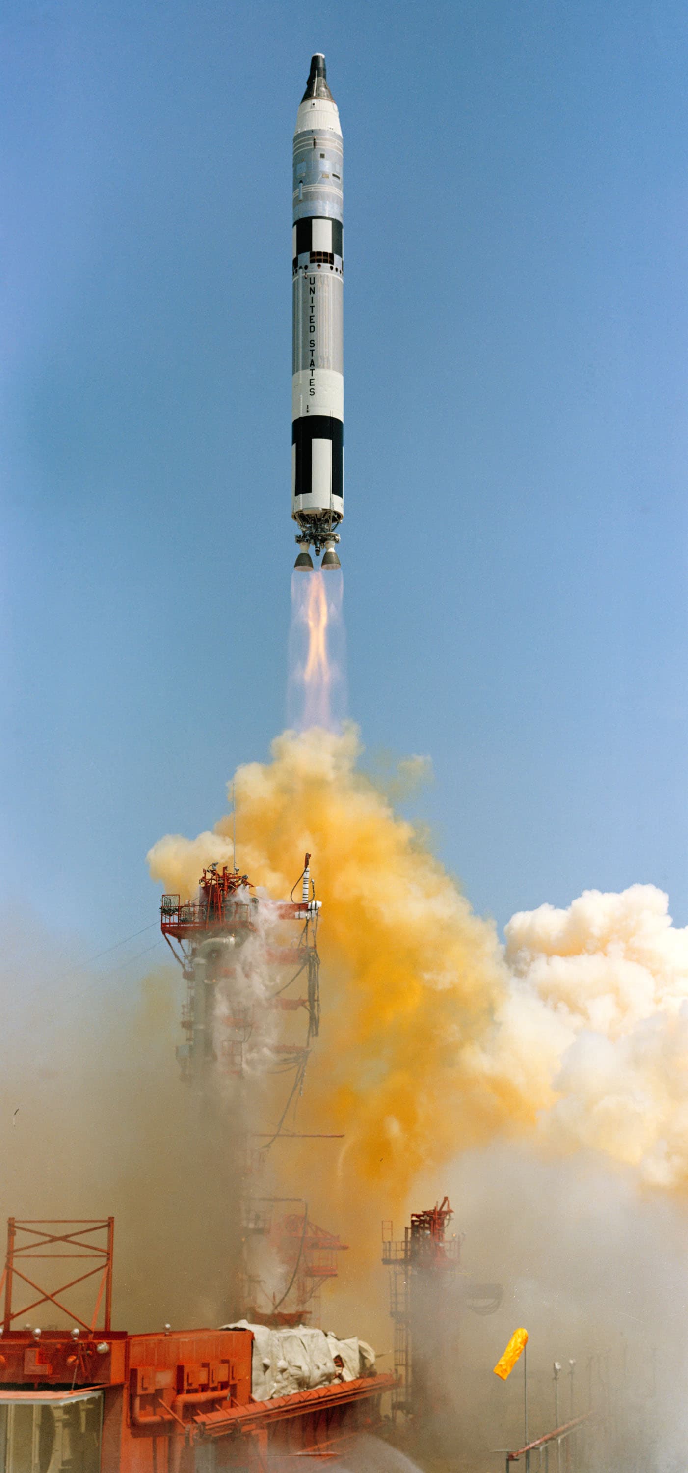 Cohete Gemini-Titan IV ascendiendo sobre la torre bajo cielo azul