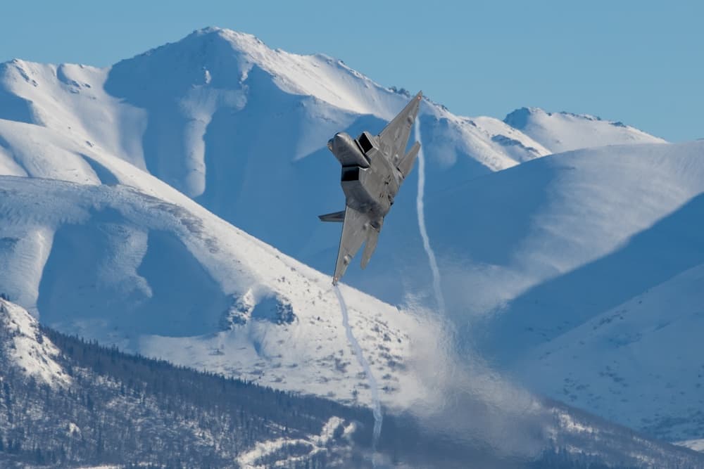 F-22 Raptor de l'U.S. Air Force au-dessus des montagnes enneigées près de Joint Base Elmendorf-Richardson en février 2023